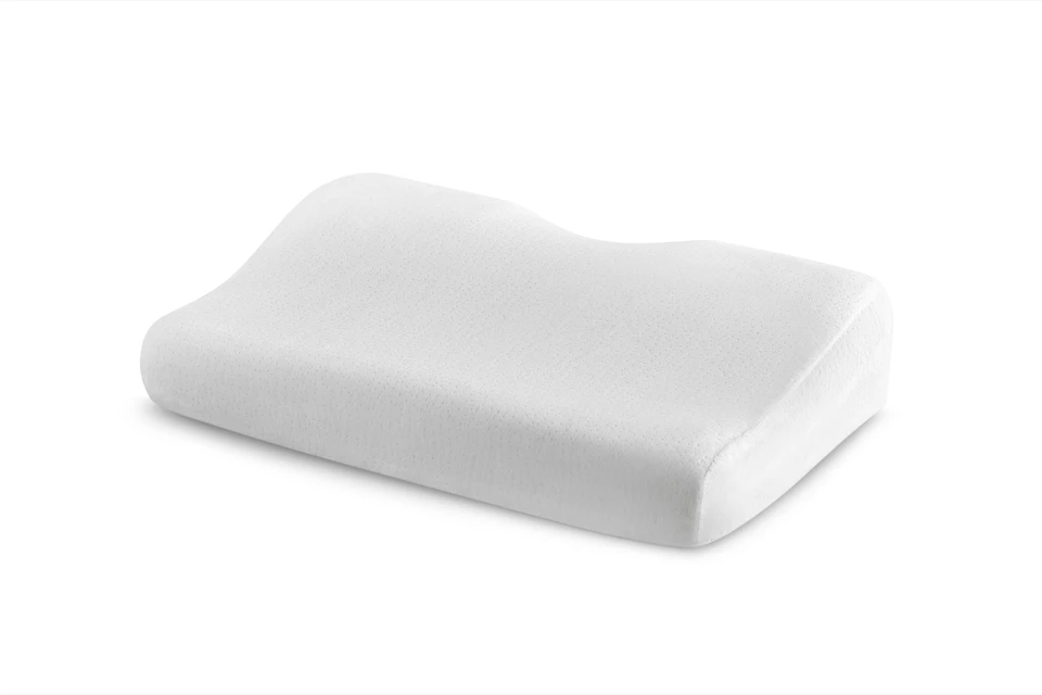 Personne en vêtement lilas positionnant un oreiller ergonomique blanc sur un lit avec literie blanche dans un environnement intérieur aux tons neutres