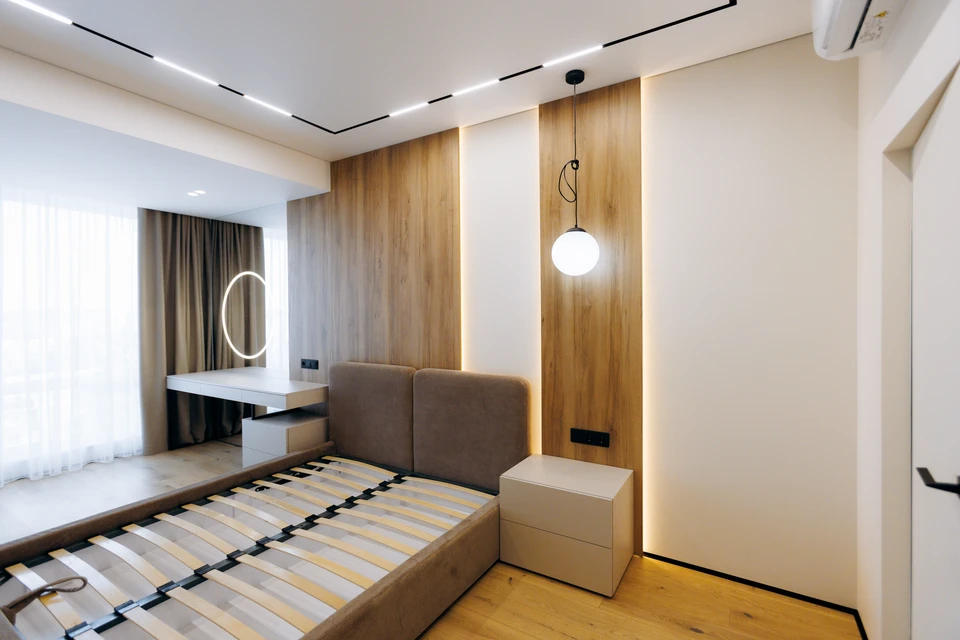 Deux commerçants professionnels en conversation chaleureuse avec une cliente au comptoir d'une petite boutique de literie, murs clairs, matelas et oreillers visibles en arrière-plan. Le vendeur écoute attentivement le client. Ambiance de commerce de proximité, conseil personnalisé sans pression commerciale.