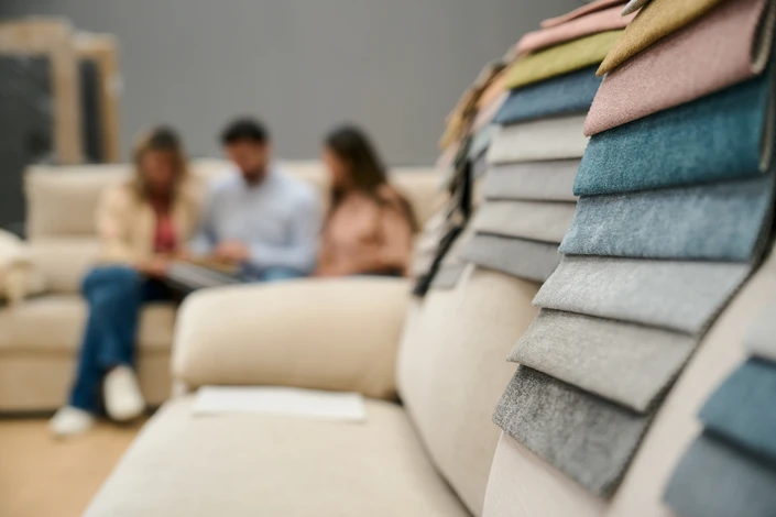 Deux associés dans leur magasin de literie, debout côte à côte souriant face à l'appareil photo, vêtus en tenue professionnelle décontractée (chemise ou polo), positionnés devant des matelas exposés en arrière-plan. Environnement lumineux et accueillant du showroom de literie.